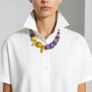 Natural Stone Necklace 0369009. Radiate confidence and individuality with this one-of-a-kind Purple & Yellow Agate Necklace, a celebration of natural beauty and vivid design. Featuring a striking combination of deep purple and bright yellow agate stones, this handcrafted natural stone necklace creates an elegant contrast that catches the eye and uplifts the spirit. Each stone is carefully selected and arranged to maximize visual impact, resulting in a festive and sophisticated necklace. Measuring 18 inches in length, the stone necklace rests gracefully along the neckline, perfectly proportioned for everyday elegance or special occasions. The natural agate stones, rich with unique patterns and translucent depth, tell their own story. Agate was first discovered by the ancient Greek philosopher Theophrastus in the Dirillo River of Sicily—then known as Acate—and has long been valued for its grounding energy and timeless beauty. This stunning natural stone necklace is perfect for adding a touch of elegance to any outfit. This piece isn’t just jewelry—it’s wearable history and vibrant artistry in one. With only a single necklace available, you’ll be wearing a truly exclusive treasure that reflects your distinctive style. Whether you choose it for its vibrant palette, its historical connection, or its rare availability, this necklace is sure to become a beloved highlight in any collection. Bold, radiant, and utterly unique.