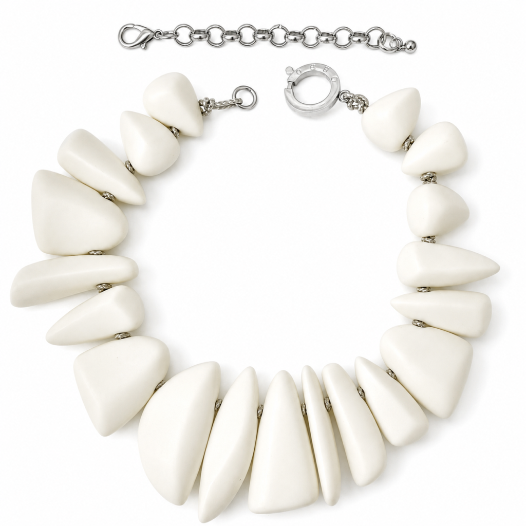 Elegant white Dior necklace featuring large matte sculptural beads in tapered geometric shapes with silver chain links and circular clasp, showcasing a modern, minimalist design.