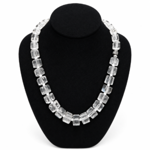 Elegant clear crystal necklace featuring rectangular faceted beads displayed on a black jewelry bust, highlighting the geometric design and luminous transparency of each bead.