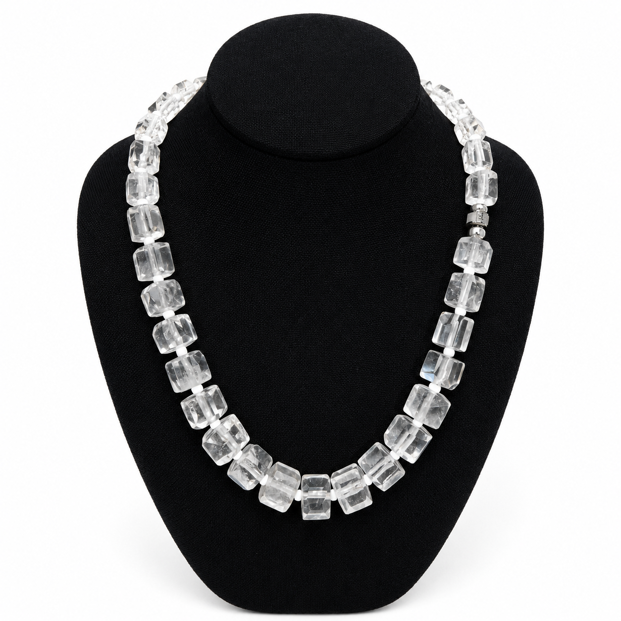 Elegant clear crystal necklace featuring rectangular faceted beads displayed on a black jewelry bust, highlighting the geometric design and luminous transparency of each bead.