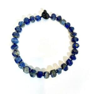 Lapis Necklace.  Channel timeless mystique and regal energy with the Lapis Lazuli Necklace—a radiant symbol of wisdom, truth, and spiritual depth. Measuring 19 inches and weighing just 6 ounces, this exquisite piece offers both comfort and statement-making style. Each irregular-shaped, semiprecious stone is hand-selected for its rich celestial blue hue and shimmering golden flecks of natural pyrite, making every necklace as unique as the person who wears it. Long revered throughout history, Lapis Lazuli once adorned the tombs of pharaohs and was ground into ultramarine pigment—the precious blue paint that illuminated Renaissance masterpieces like Michelangelo’s Sistine Chapel. Its deep, evocative color continues to symbolize inner vision, intuition, and clarity of mind. More than a necklace, this piece is an invitation to connect with your higher self. It's favored by those drawn to meditation, emotional healing, or simply the magnetic beauty of a stone that reflects both the heavens and the soul. The natural, irregular shape of each bead adds artisanal charm, enhancing its raw elegance. Whether worn as a sacred talisman or a bold fashion statement, the Lapis Lazuli Necklace is a tribute to the inner light that guides us. Add this captivating piece to your collection and wear your insight with pride.