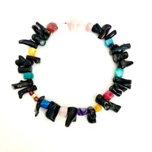 Handcrafted Black Coral Necklace displayed on a white background, featuring polished black coral beads interspersed with multicolor agate stones and a rose quartz toggle clasp. The design highlights vibrant contrast and artisanal craftsmanship.