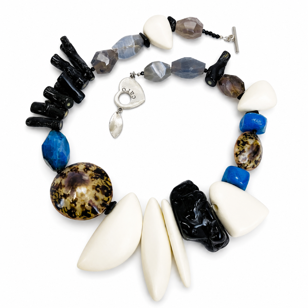 Handcrafted Bohemian Necklace featuring black coral, blue and gray agates, brown shell, and ivory resin beads with a silver toggle clasp engraved “CARO” and leaf charm.
