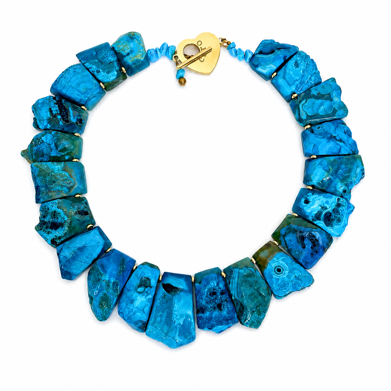 Handcrafted necklace featuring large polished blue agate stones in varying shades of turquoise and cerulean, accented with gold spacers and a gold heart clasp engraved “Caro.” The design highlights natural texture and radiant color.