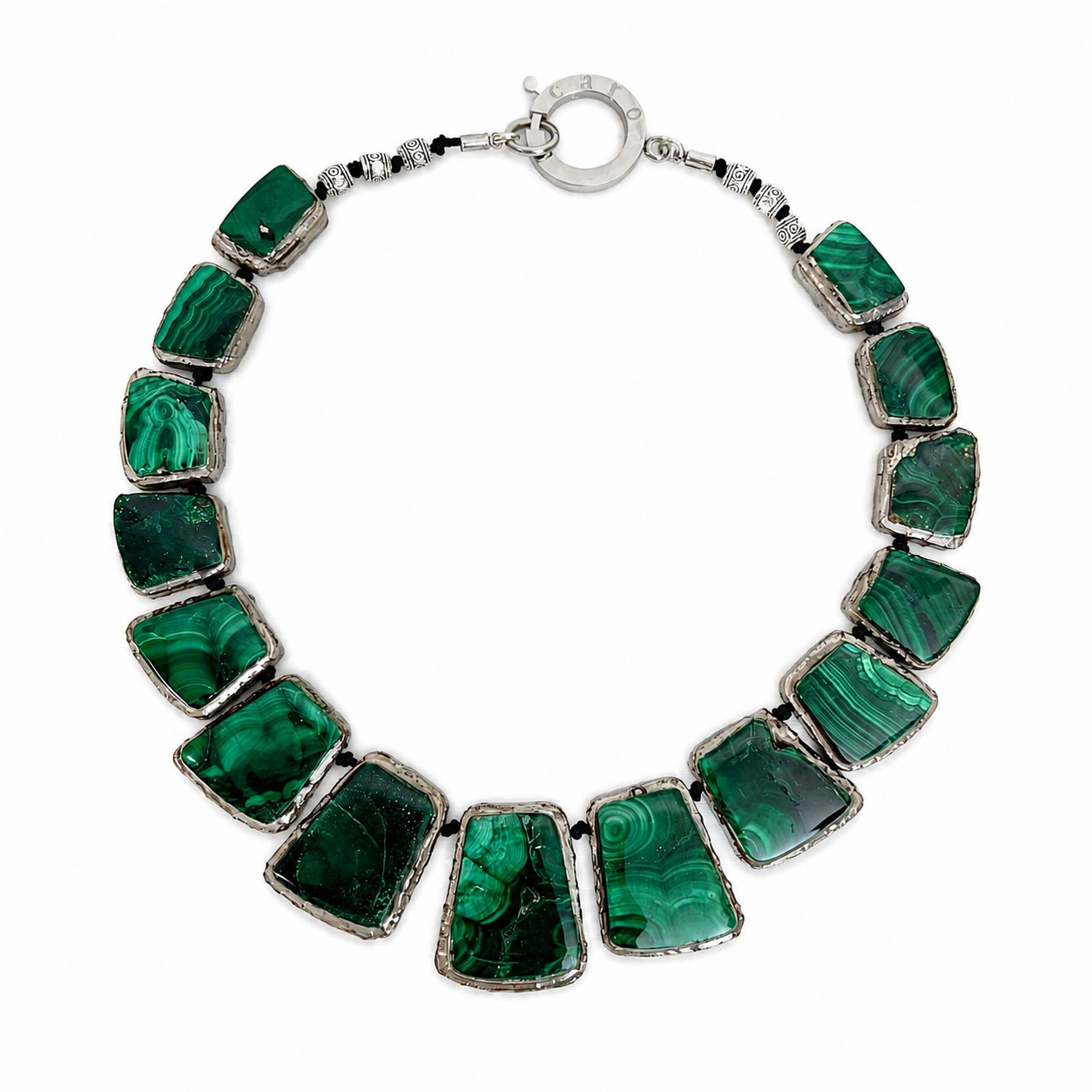 Handcrafted necklace featuring rectangular and trapezoidal polished malachite stones with natural green banding patterns, set in silver frames and finished with a silver clasp engraved “Caro.”