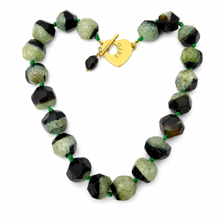 Handcrafted necklace featuring alternating faceted green and black agate stones with natural crystalline texture, connected by green knots and finished with a gold heart clasp engraved “Caro.” The design highlights organic beauty and refined craftsmanship.