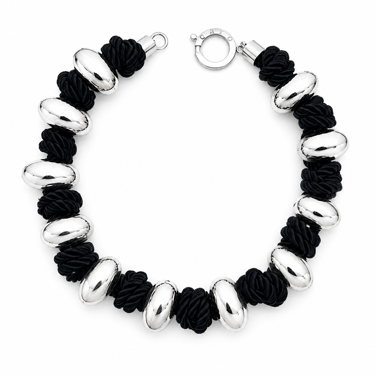 Handcrafted necklace featuring alternating polished silver‑tone oval beads and twisted black cord segments, finished with a circular silver clasp engraved “Caro.” The design highlights bold contrast and contemporary craftsmanship.