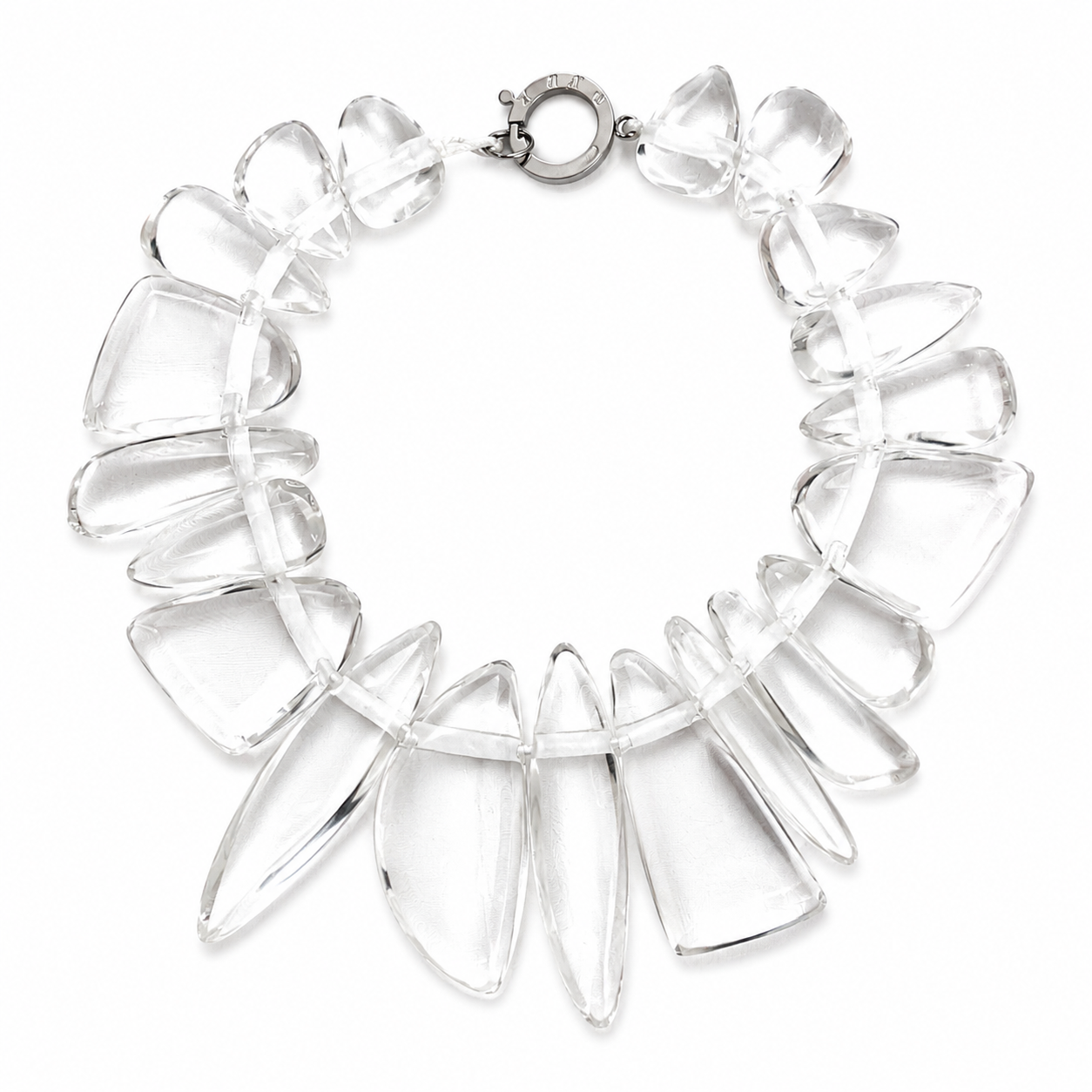 Handcrafted necklace featuring irregular clear acrylic beads arranged in a circular design with a silver‑tone clasp engraved “Caro.” The transparent beads create an ice‑like effect, highlighting modern craftsmanship and minimalist elegance.