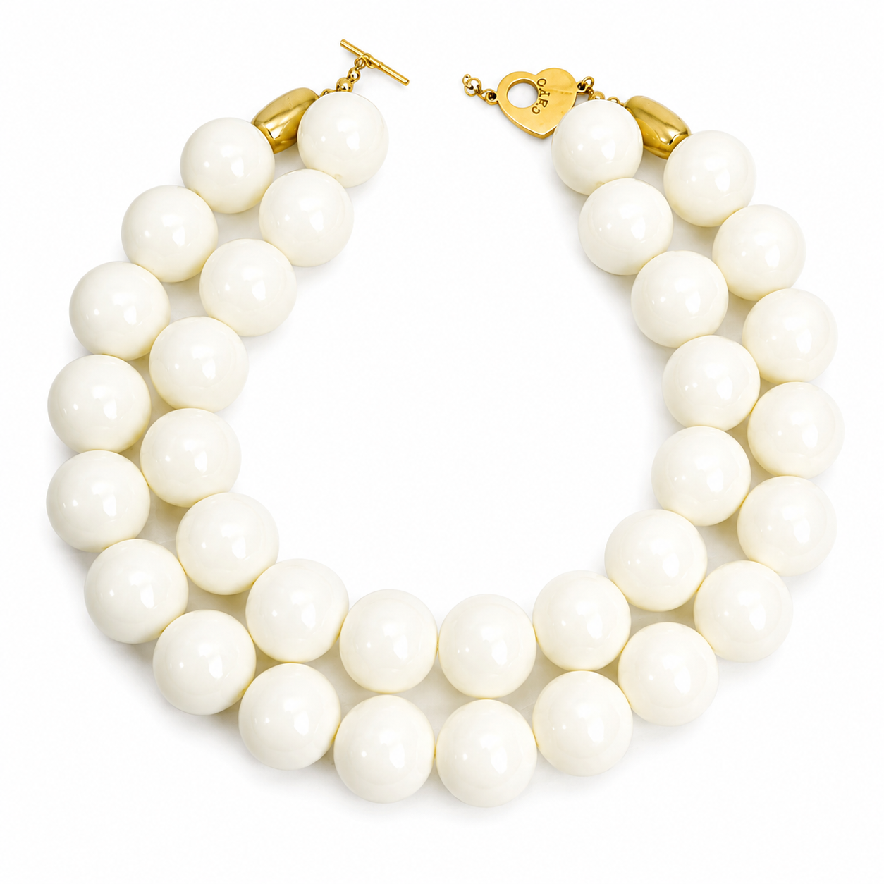 Handcrafted double‑strand necklace featuring large glossy ivory beads with gold‑tone hardware and a heart‑shaped clasp engraved “Caro.” The design highlights timeless sophistication and polished craftsmanship.