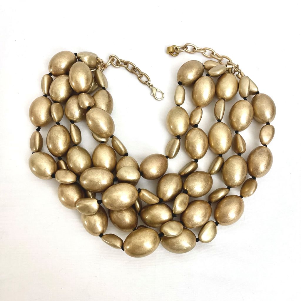 Handcrafted necklace featuring lightweight matte gold beads arranged in a long, full silhouette. The soft matte finish creates an exotic, sculptural look ideal for daytime wear.