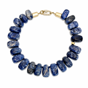 Handcrafted necklace featuring large polished Sodalite stones in deep royal blue with white marbling, strung on a blue cord with gold‑tone clasp.