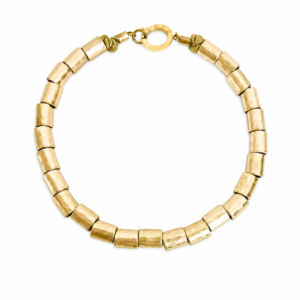 Handcrafted necklace featuring cylindrical matte gold beads arranged in a uniform strand with a round gold clasp engraved “Caro.” Displayed on a white background.