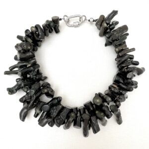 Make an enduring impression with the Double Strand Necklace—a refined creation that balances natural artistry with timeless elegance. This all-natural piece showcases two flowing strands of black coral, each with its own distinctive texture and organic charm. The rich, deep hue and intricate surface of the coral exude understated sophistication, making this necklace a wearable masterpiece for those with an eye for detail and quality craftsmanship. Designed to offer versatility, the double strand necklace silhouette creates a layered effect that’s both graceful and bold. Whether worn solo for a minimalist statement or paired with complementary pieces, it adapts effortlessly to your personal style and occasion. From casual daytime strolls to elegant evening affairs, the necklace transitions seamlessly, offering a polished touch that elevates any ensemble. Each strand reflects the beauty of nature and the care of skilled artisans, blending simplicity and luxury in equal measure. The tactile texture of the coral adds depth and intrigue, while the balanced proportions ensure comfortable wear and visual harmony. For those who value elegance born of nature and elevated by design, the Double Strand Black Coral Necklace is an essential addition—a piece that speaks softly but leaves a lasting impression.