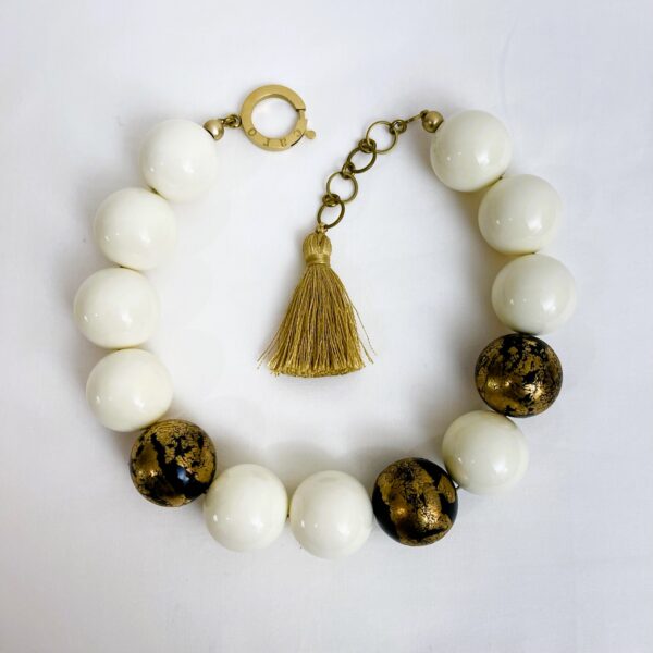 Ivory color beads with black beads foiled in gold leaf. The necklace can be a choker or elongated up to 19 inches.