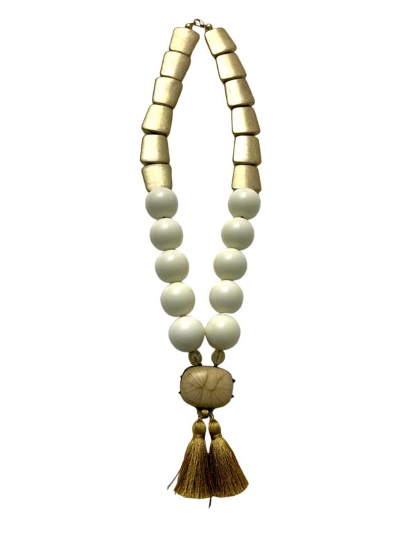 Tribal style long necklace; ivory acrylic beads, matte gold beads with resin pendant, and silk tassel.  See the layering sample with additional products 0369085 and 0369087 for a fuller look, sold separately.