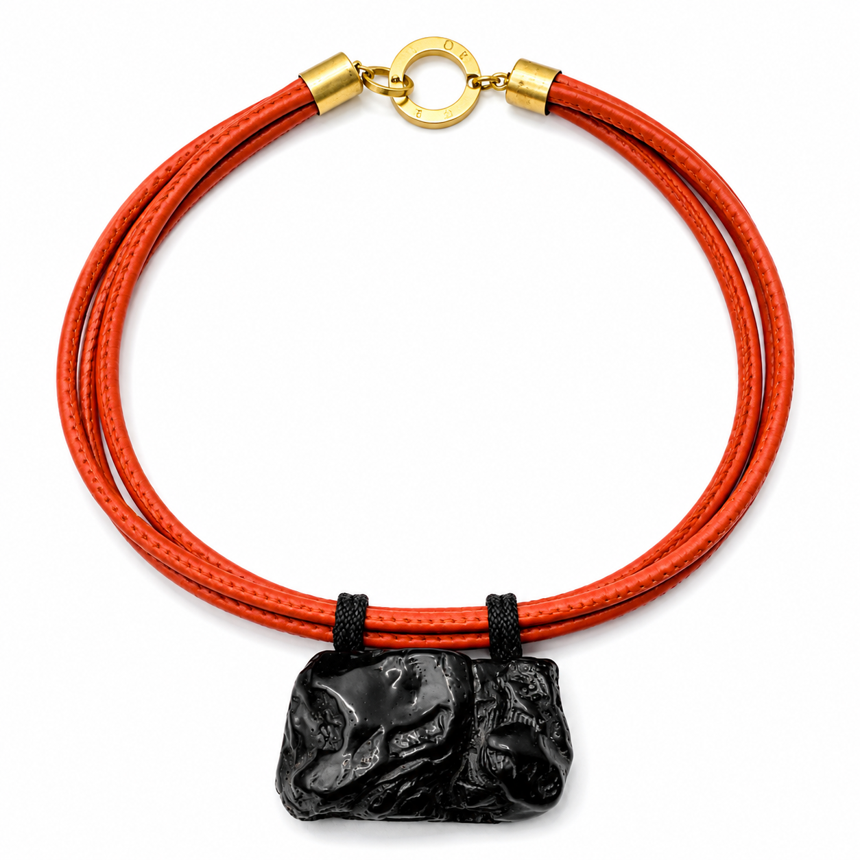 Necklace featuring a natural black coral pendant attached to double strands of orange PU leather with gold metal clasp, displayed on a white background.