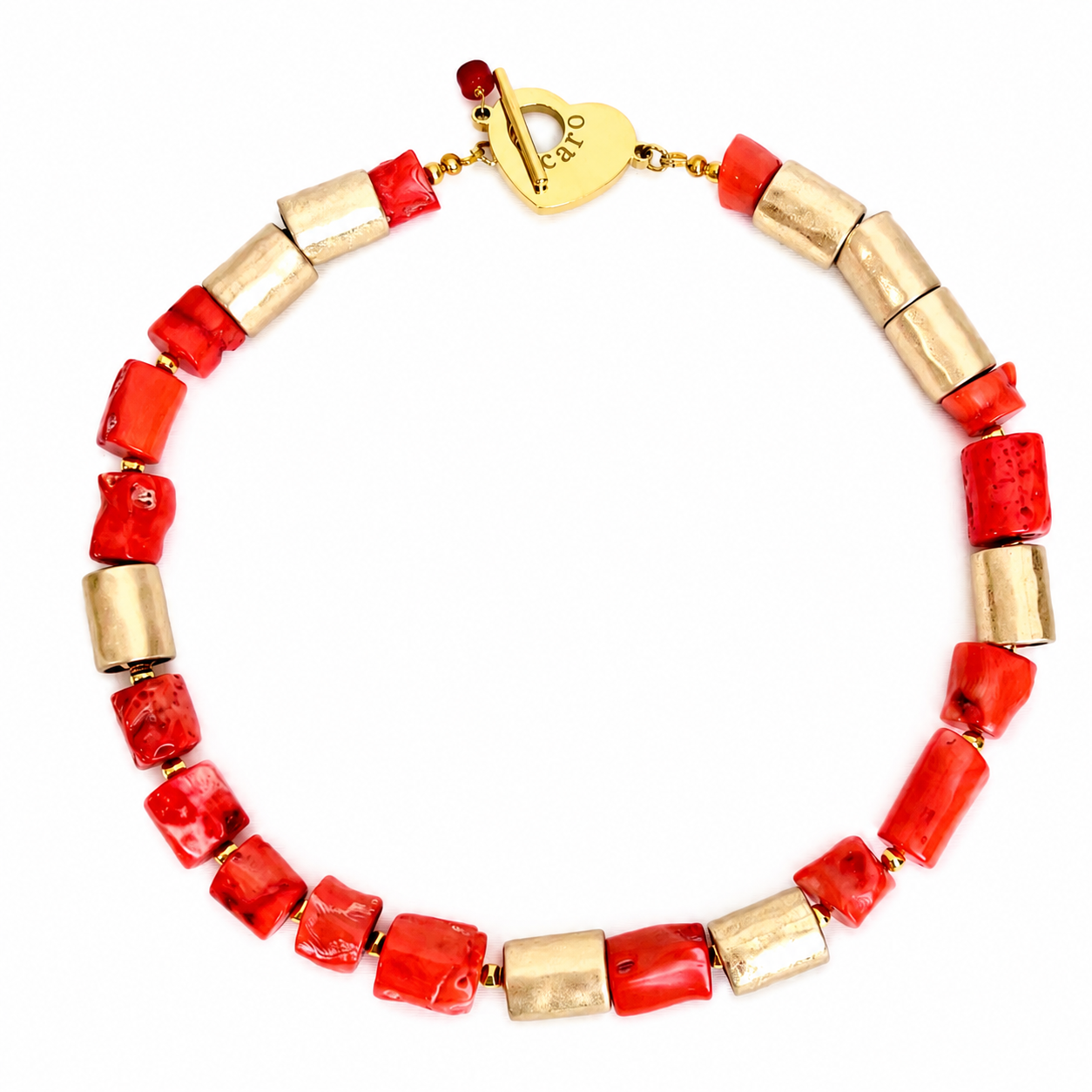 Handcrafted necklace featuring alternating irregular orange coral beads and cylindrical gold accents with a heart‑shaped clasp engraved “Caro.” Displayed on a white background.