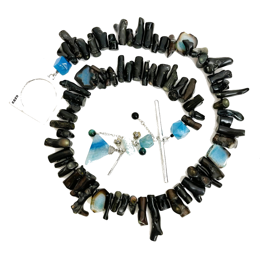Handcrafted Long Necklace featuring natural black coral branches and vibrant blue agate stones, accented with silver hardware and an oversized square clasp engraved “Caro.” Includes dangling lotus‑inspired charms with geometric blue stones, displayed on a white background highlighting its bold contrast and artisanal design.