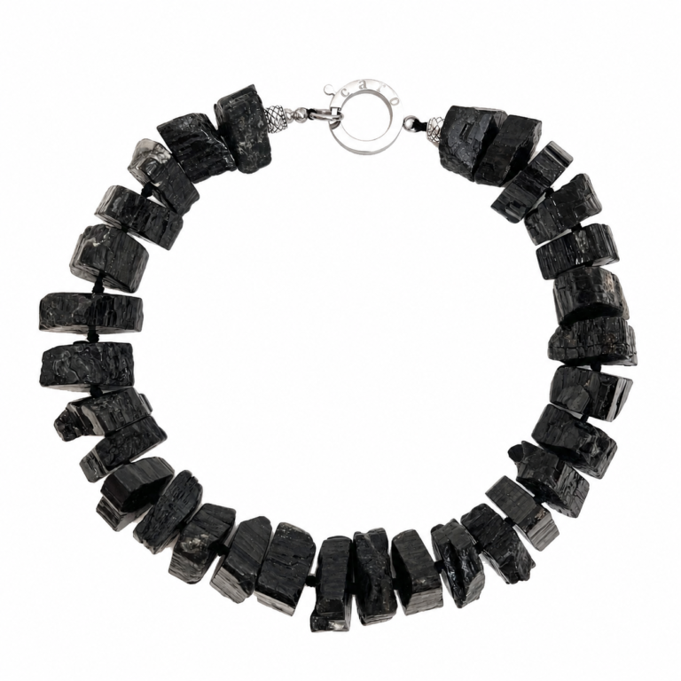 Handcrafted Tourmaline Necklace composed of large, irregular black tourmaline stones with a silver clasp engraved “Caro.” Displayed on a white background, emphasizing the necklace’s rough texture, organic form, and artisanal craftsmanship.