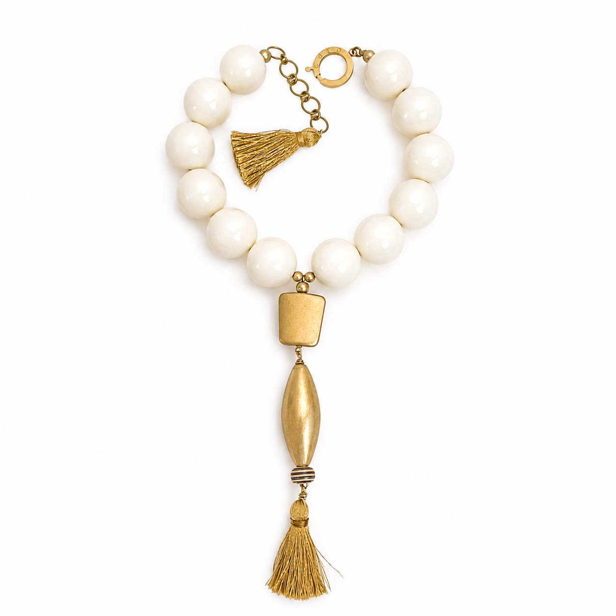 Caro Original chunky necklace with glossy ivory beads, matte gold geometric and elongated pendants, and a golden tassel accent.