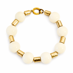 Ivory choker necklace featuring large smooth ivory beads and antique‑gold cylindrical spacers arranged in a circle on a neutral background.