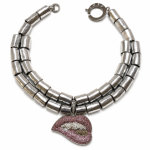 Double‑strand silver choker necklace featuring large cylindrical metallic beads and a pink rhinestone lip pendant with crystal teeth detail.