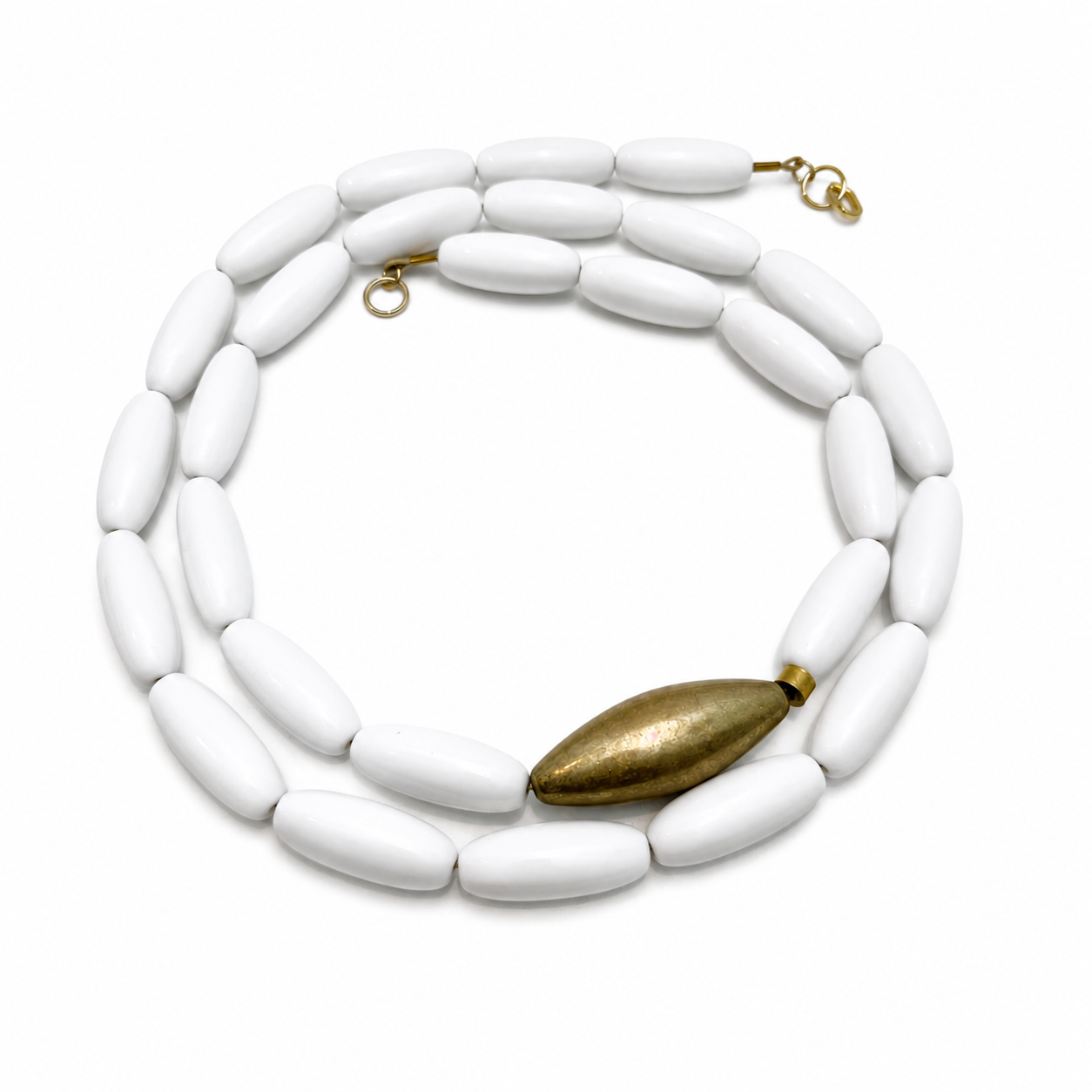 Long single‑strand necklace featuring smooth oval white beads and one large gold accent bead, displayed on a white background.