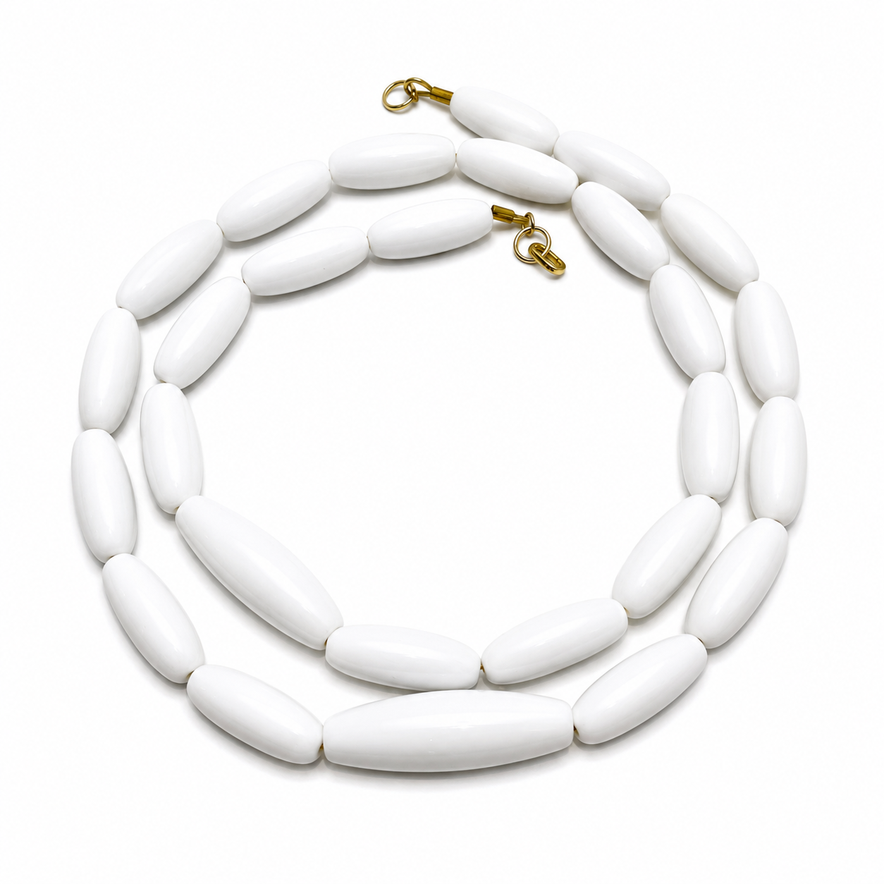 Long single‑strand necklace featuring smooth oval white beads with gold clasps, arranged in a circular pattern on a white background.
