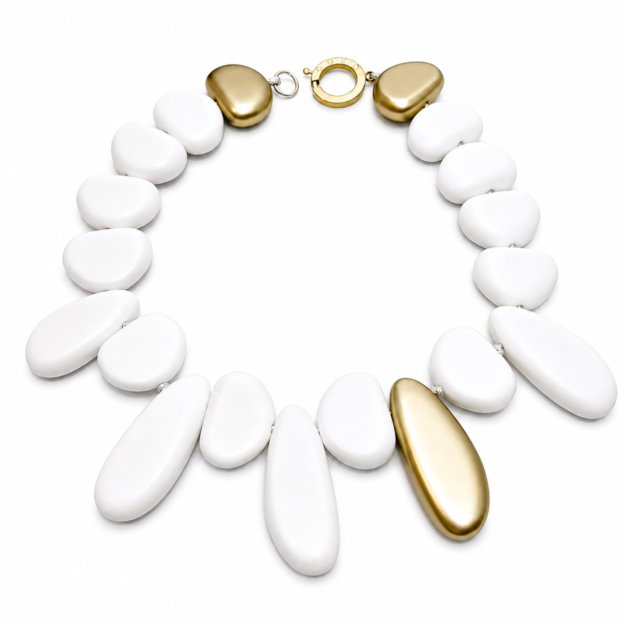 White and gold irregular‑shaped bead necklace arranged in a circular formation on a light background, featuring matte white beads and two metallic gold accent beads.