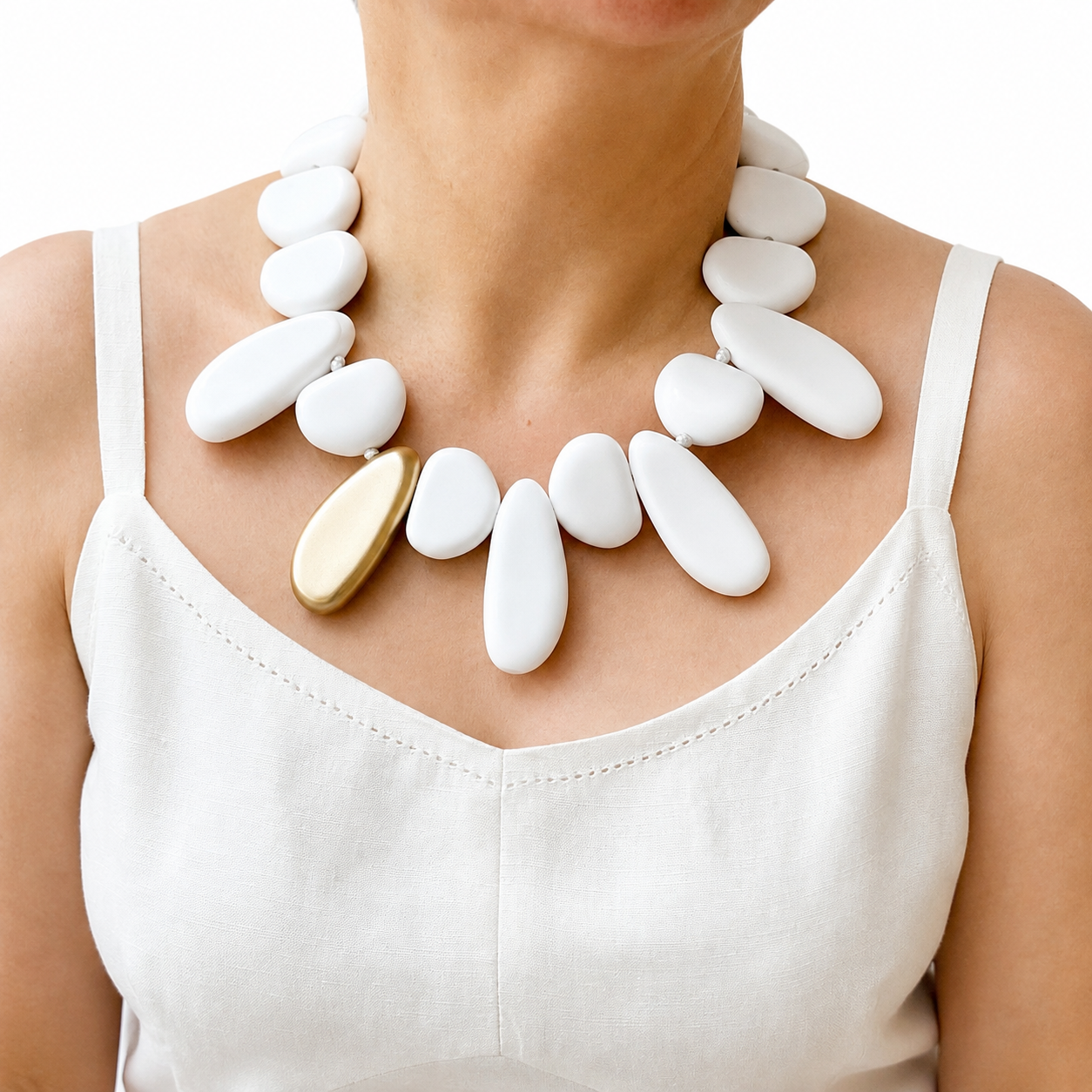 Model wearing a white and gold irregular‑shaped bead choker necklace with matte finish, styled with a white sleeveless dress for a minimalist summer look.