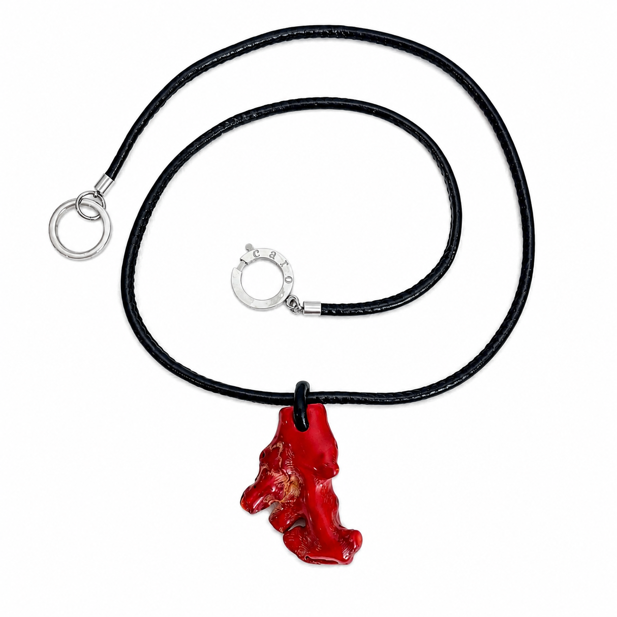 Black cord necklace featuring an irregularly shaped red coral pendant with a silver clasp engraved “Caro,” displayed on a white background.