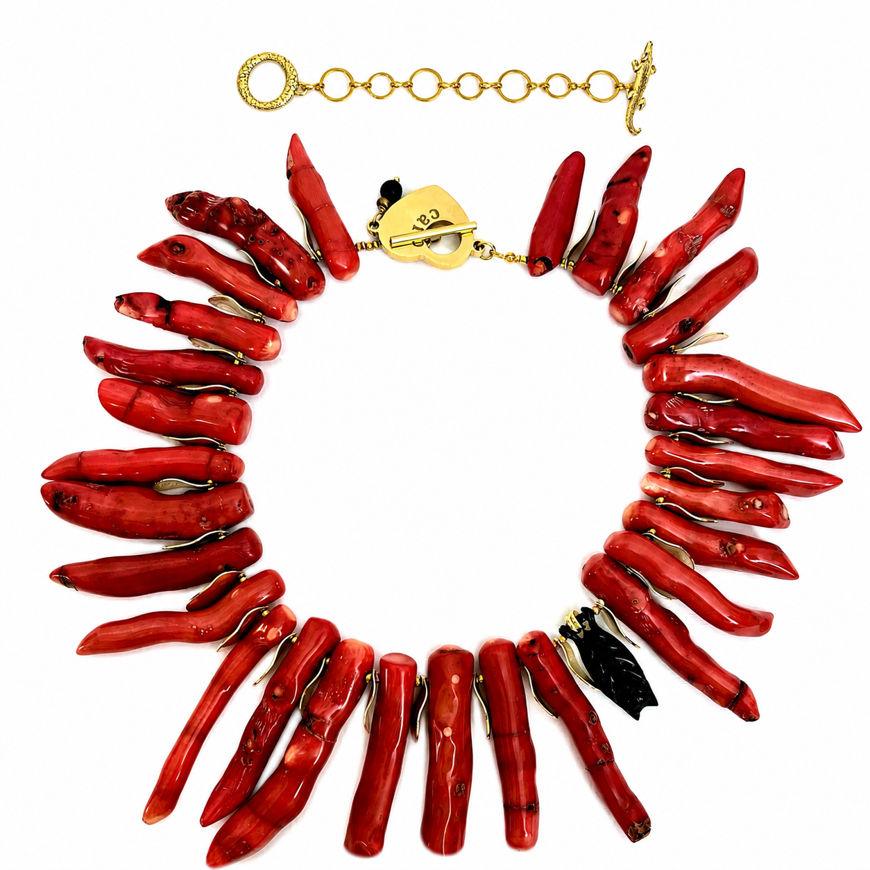 Statement necklace featuring elongated red coral branches arranged in a circular pattern with a gold clasp engraved “caro,” displayed on a black background.