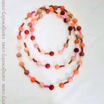 Long necklace measuring 34 inches long made of soft silicon beads in peach and pink color.