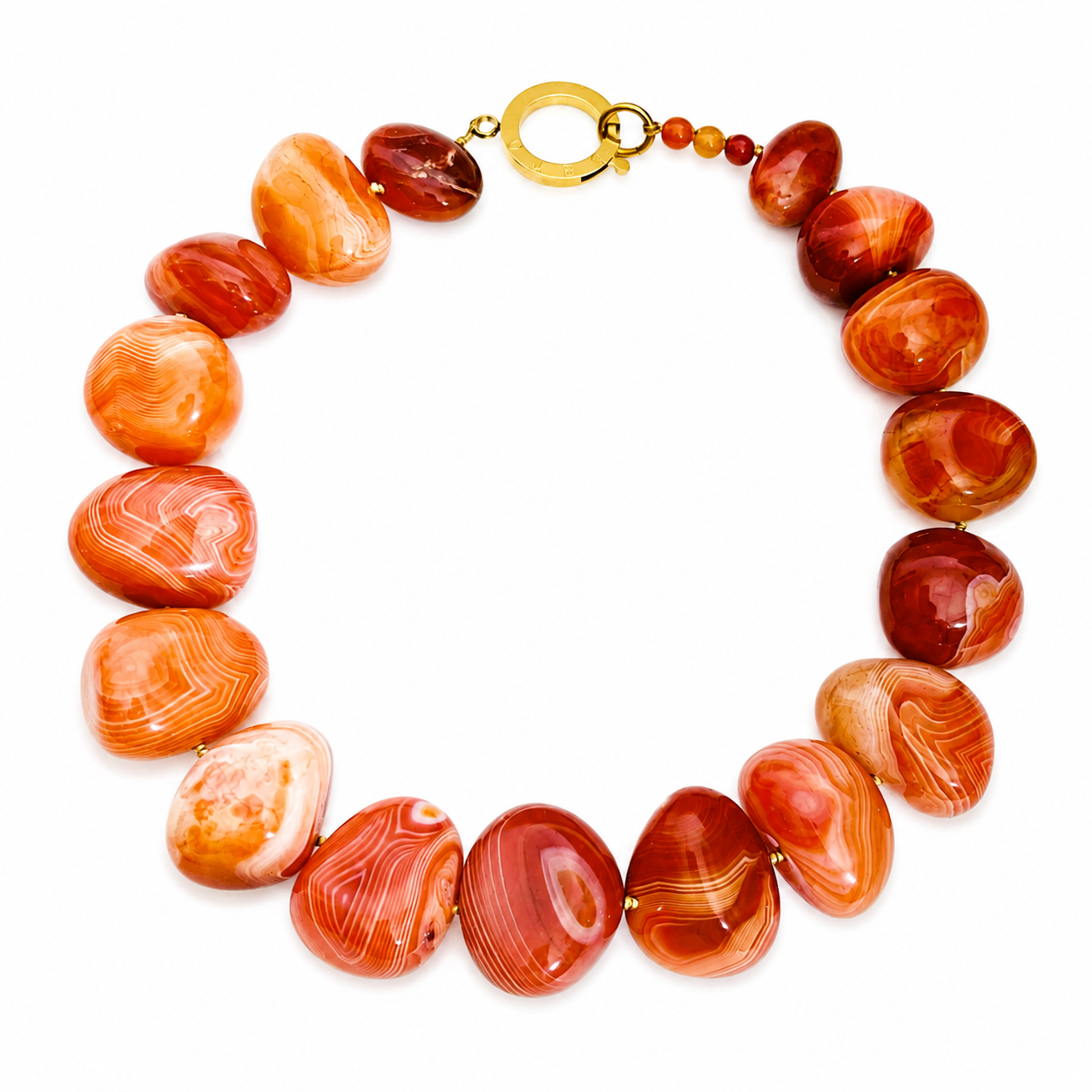 Handcrafted necklace featuring polished, irregularly shaped red Carnelian stones with natural banding and high‑shine finish, arranged in a circular formation and secured with a gold clasp engraved “Caro.” Displayed on a white background.