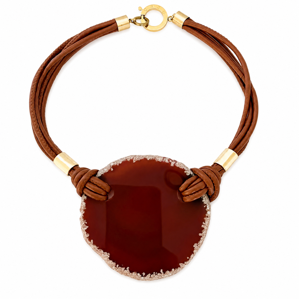 Handcrafted necklace featuring a large, circular red Carnelian pendant with a crystalline edge, suspended from multiple brown PU leather cords secured by gold-tone metal fittings and a round clasp engraved “Caro,” displayed on a white background.