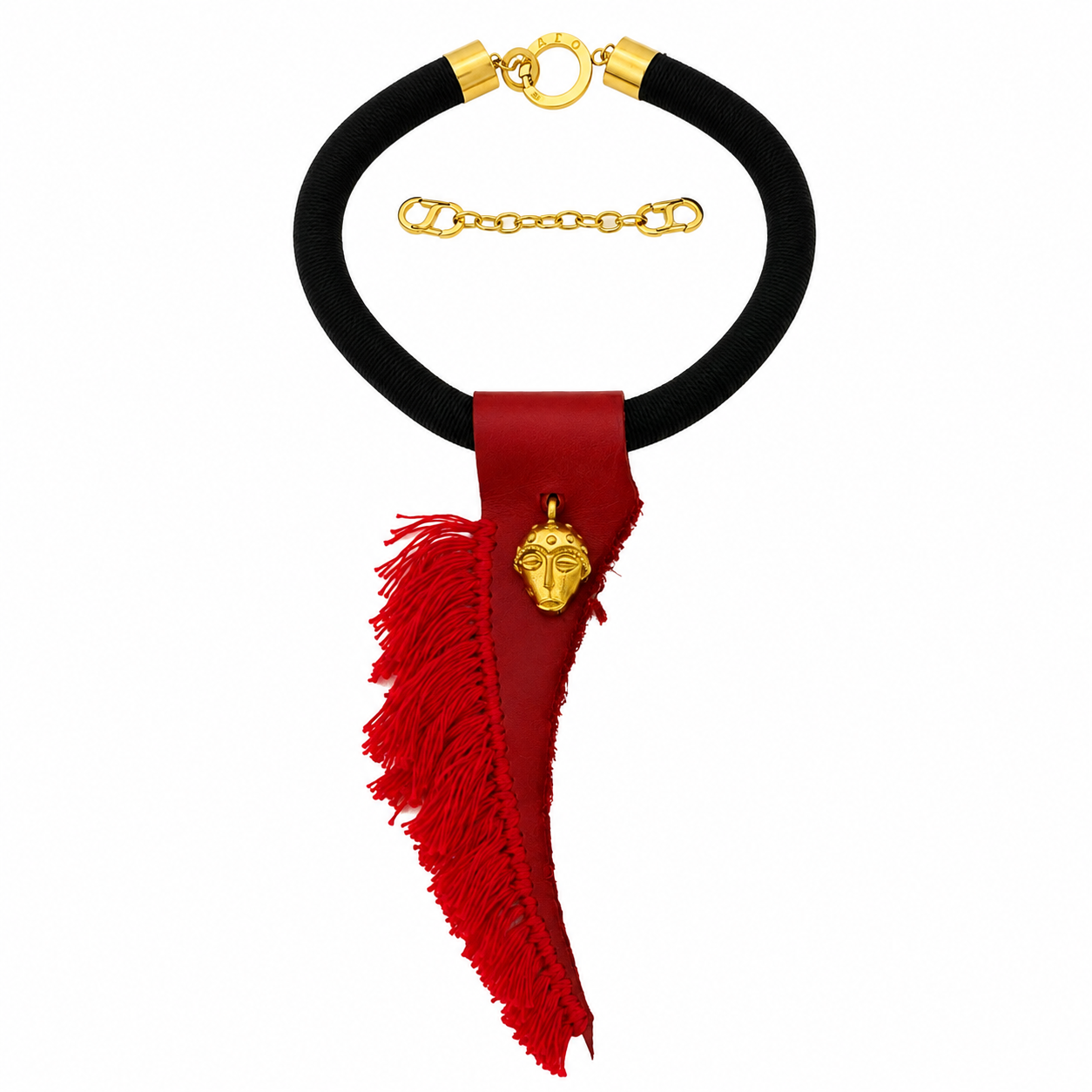 Handcrafted tribal-inspired necklace featuring a thick black suede cord with gold-tone end caps and clasp engraved “Caro.” A red leather pendant with fringed edges hangs from the center, adorned with a small brass mask charm symbolizing ancestral artistry.