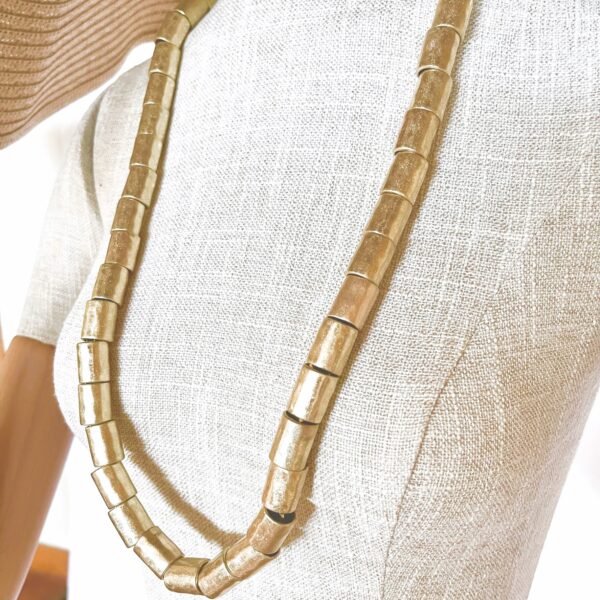 Edgy with refinement, this punk long-style punk necklace is a bold nod to rebellion—crafted with a dash of sophistication. Measuring 33 inches (84 cm), its generous length makes it effortlessly versatile, flowing with grace for both daytime defiance and nighttime glam. Whether draped over denim or paired with sleek tailoring, it redefines punk as poised and intentional. A series of antique gold cylindrical beads form the heart of its punk design, channeling grit through gleaming elegance. These metallic accents lend an industrial vibe softened by their vintage luster, creating a dynamic contrast between raw attitude and curated style. It's punk—but with class. What truly sets this necklace apart is the subtle tension between form and finish. The choice of tones, bead shape, and extended length infuses the punk piece with movement and personality. It's perfect for those who walk the line between statement and subtlety, for those who embrace individuality with polish. Wear it layered, looped, or standalone—it’s your personal manifesto, wrapped in gold-toned attitude, you can add a touch of punk to your style, but with elegance.