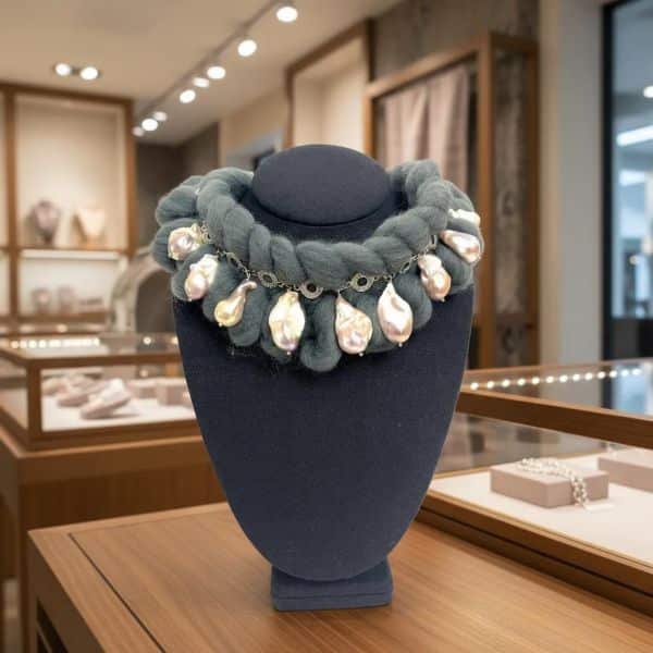 Winter Necklace Where warmth meets elegance. Crafted for the season of stillness and snow, this necklace blends cozy texture with luminous beauty. A thick band of bulky yarn wraps gently around the neck, offering both comfort and style. Suspended from a silver chain, a cascade of natural baroque pearls adds organic charm—each one uniquely shaped, with soft iridescence in tones of cream, blush, and gold. Designed to be worn like a scarf but styled as a statement piece, the Winter necklace is more than an accessory—it’s a tactile experience. The yarn provides warmth on brisk days, while the pearls evoke frost-kissed petals and frozen dew. This juxtaposition of rugged textile and delicate luster makes it ideal for layered looks, whether over a ribbed sweater or peeking from beneath a wool coat. Baroque pearls, known for their irregular forms and rich history, have long symbolized individuality and resilience—qualities that echo the spirit of Winter. With each pearl hand-selected for its character, the necklace becomes a wearable celebration of nature’s imperfections. Let Winter wrap around you—not just in temperature, but in texture, tone, and timeless grace. This piece speaks softly, like snowfall, and shines boldly, like ice under moonlight.