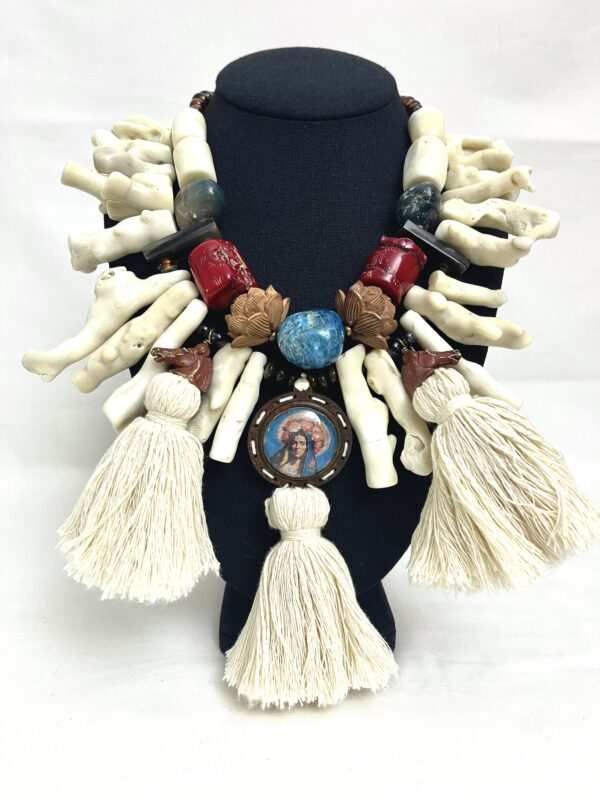 An exotic combination of natural stones, tassels, a wood medallion, brass horses, Coral, Bone, glass, Labradorite, Apatite, and sandalwood.  The necklace measures 19 INC/46 CM, 19 OZ.