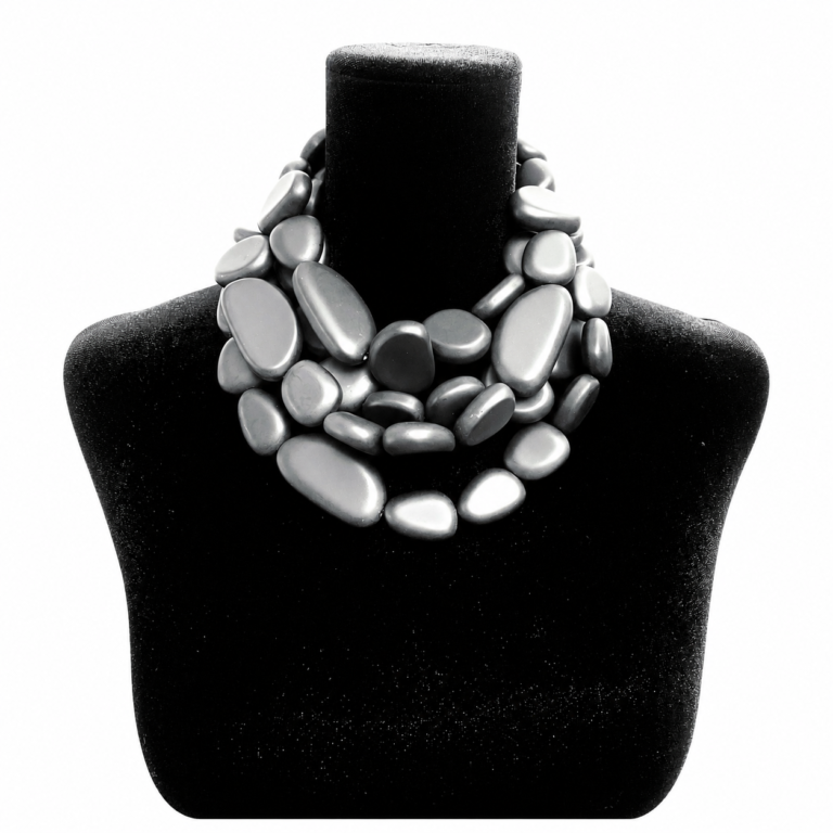 Black velvet jewelry bust displaying a multi-strand necklace made of smooth, matte black oval beads arranged in overlapping layers, forming a sculptural, mosaic-like design.