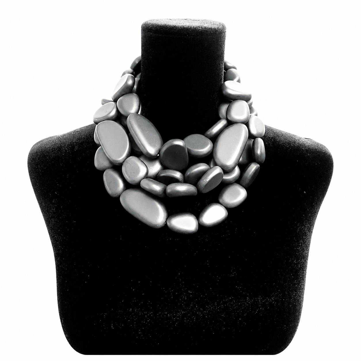 Black velvet jewelry bust displaying a multi-strand necklace made of smooth, matte black oval beads arranged in overlapping layers, forming a sculptural, mosaic-like design.