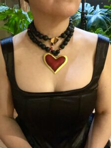 Long statement necklace made of black silicone beads with a large red heart pendant.  The necklace measures 33IN/84CM/6OZ.