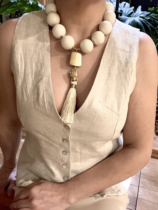 Exotic ivory color round acrylic beads with gold tiger head and silk tassel tongue pendant.  It is a classic color with an elegant accent bead to make a statement.  The necklace measures 18IN/11OZ and can extend up to 24IN.