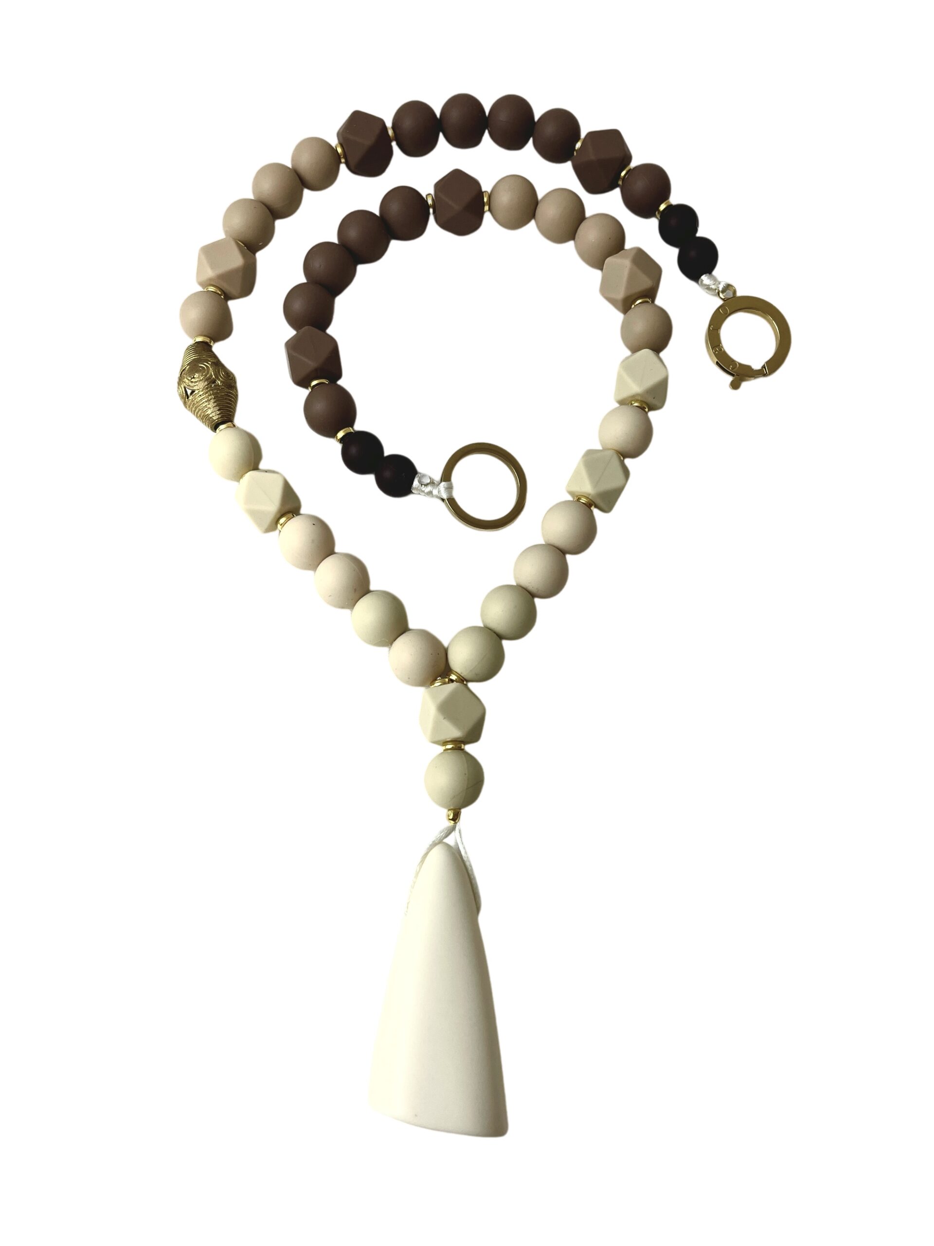 Beaded necklace featuring a gradient of cream to chocolate-brown silicone beads in round and faceted shapes, accented with gold details and a textured metallic bead. The design culminates in a large, smooth ivory pendant with an organic, tapered shape.