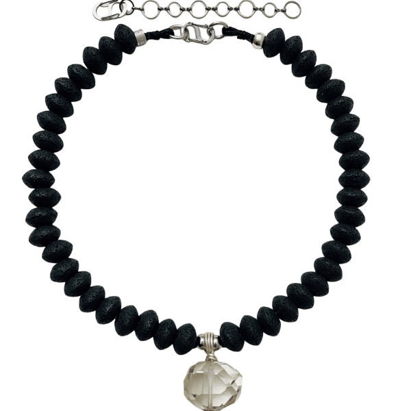 🔥 Bold, balanced, and quietly powerful—the Lava Necklace blends timeless elegance with elemental energy. Measuring 20 inches and extending to 24 inches, its adjustable fit allows seamless styling from close-choker intimacy to a graceful drape. At just 4 ounces, it promises lightweight comfort without sacrificing visual impact. At the heart of this piece is the lava stone—porous, volcanic, and ancient. More than just a raw material, lava has been revered for its grounding properties since before written history. Its coarse texture not only adds an earthy aesthetic but also serves a unique purpose: a perfect surface for infusing essential oils. Simply apply your favorite scent and let the stone become a gentle diffuser, wrapping you in fragrance and calm throughout your day. Paired with a polished rock crystal, the necklace plays with contrast—rough and smooth, matte and shine, serenity and clarity. In spiritual circles, this combination is seen as a potent conduit for balancing emotional turbulence: lava’s stabilizing energy unites with the crystal’s purifying light, creating a wearable harmony. Whether worn for its striking look, spiritual symbolism, or therapeutic intention, the Lava Necklace is a versatile talisman. A single glance reveals its quiet power; a single wear connects you to something deeper—resilience, clarity, and centered style.