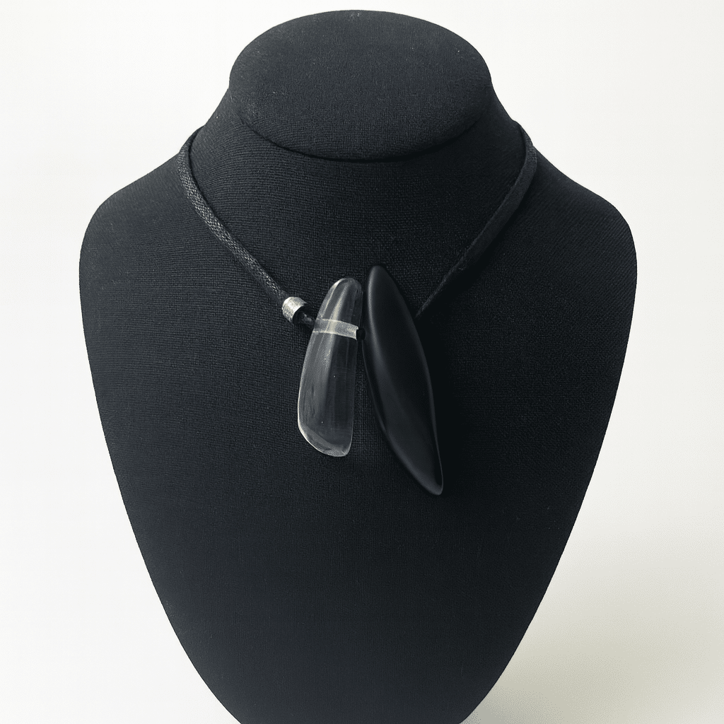 🖤 Sleek and simple; adaptable, and effortlessly refined—the black cotton cord necklace is a statement in minimalist sophistication with a thoughtful nod to practicality. Designed for versatility, it seamlessly shifts from a snug choker to a graceful 29-inch drape, allowing you to tailor the fit to your mood and outfit. Its lightweight construction makes it an ideal travel companion, offering all-day comfort without compromising on impact. Whether you're heading to a gallery opening or slipping into something casual for brunch, this simple but sophisticated piece adapts to any occasion with ease. The dual-pendant design—a bold black matte resin paired with a transparent counterpart—creates visual contrast and depth while staying true to a modern, simple, understated aesthetic. The pairing invites quiet contemplation: light and shadow, transparency and opacity, softness and strength. Set against the clean line of the cotton cord, these elements work together to evoke subtle elegance with a contemporary edge. It’s a necklace that doesn’t shout—it whispers taste, thoughtfulness, and individuality. Perfect for those who value form and function, this piece elevates your style while keeping pace with your lifestyle. Wear it your way, wherever the day takes you.