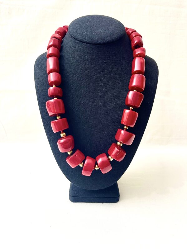 The necklace is a stunning display of natural deep red polished Coral beads in cylindrical shapes with a black stone toggle clasp. It measures 24 IN/11 OZ and is a true red, a little dressy and casual. The necklace is handcrafted, eye-catching, and timeless.