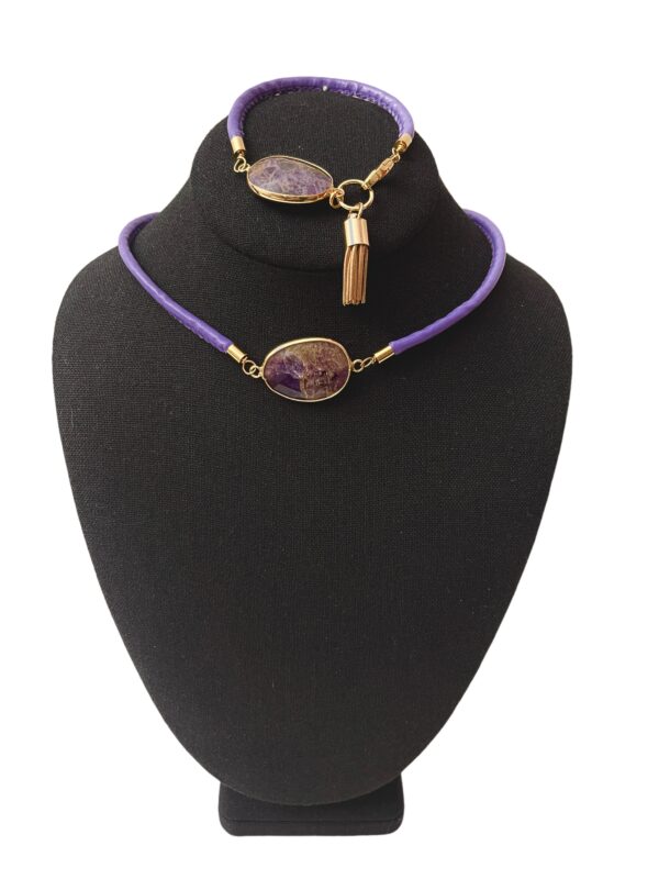 This is a choker necklace and bracelet set. The necklace has a single Amethyst pendant and a matching bracelet. The pendant is a faceted Amethyst natural stone on a purple vegan leather cord. The necklace measures 16 IN/2 OZ and includes an extender to make it up to 20 IN long.