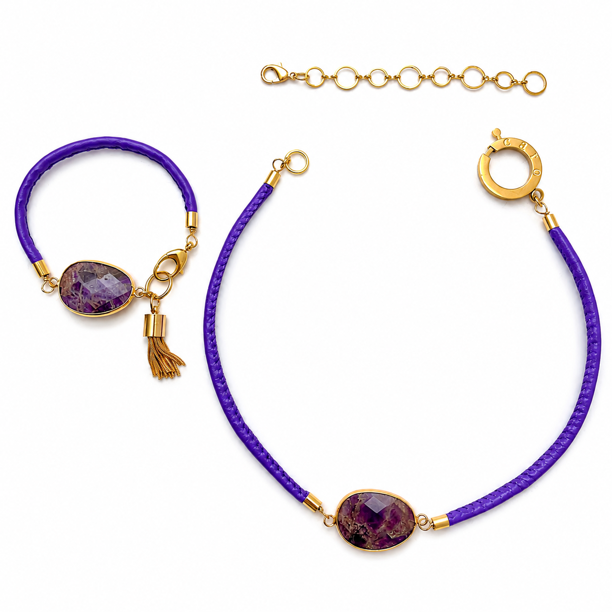 Jewelry set featuring a purple amethyst necklace and matching bracelet with gold accents. Both pieces have a faceted oval gemstone centerpiece set in gold, attached to purple cords. The bracelet includes a small gold tassel charm.
