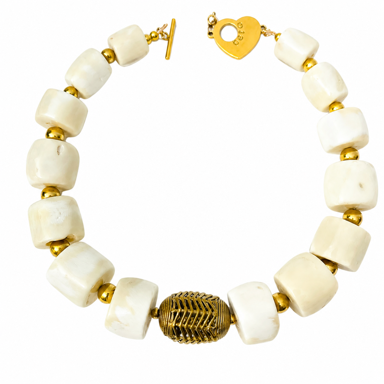 Close-up of the Mars Necklace featuring large cube-shaped white coral beads separated by small gold spheres, with a central ornate gold bead and a heart-shaped toggle clasp engraved “Caro.”